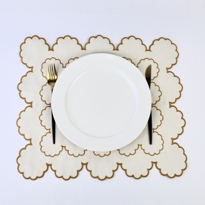 Prato branco sobre chávena branca com detalhes dourados e talheres com cabos pretos