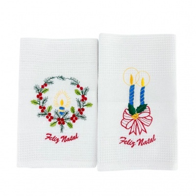 Toalhas brancas com bordados de Natal e texto 'Feliz Natal' em vermelho.