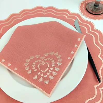 Jogo americano e guardanapo rosa salmão com bordas brancas e bordado de corações brancos