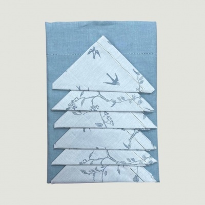 Guardanapos de tecido azul e branco com padrão de ramos e pássaros