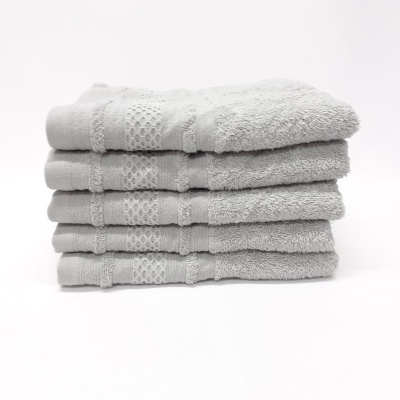 Conjunto de cinco toalhas cinzentas empilhadas com faixa decorativa