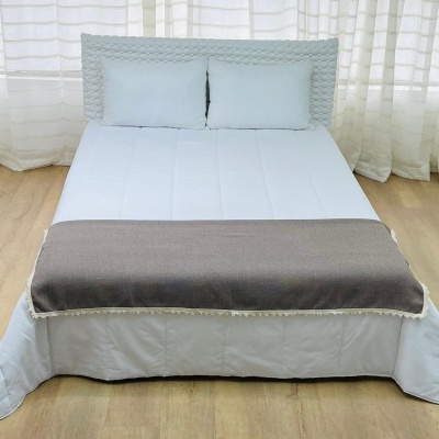 Cama de casal com colchão branco e cobertor cinza