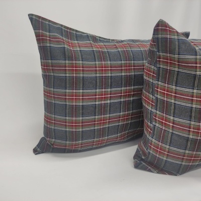 Duas almofadas xadrez azuis, vermelhas e brancas sobre superfície branca