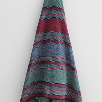 Toalha com riscas coloridas pendurada numa parede branca