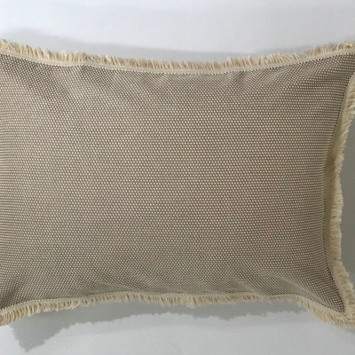 Travesseiro retangular bege com textura trançada e franjas nas bordas