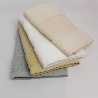 Toalhas de banho empilhadas em várias cores claras com faixa texturada no centro