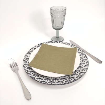 Conjunto de prato, talheres, guardanapo verde e copo de vidro com padrão geométrico
