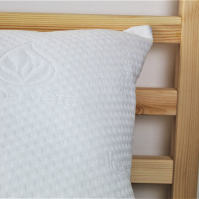 Travesseiro branco texturizado com cabeceira de madeira clara