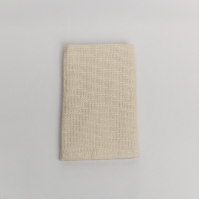 Toalha bege claro com padrão quadriculado