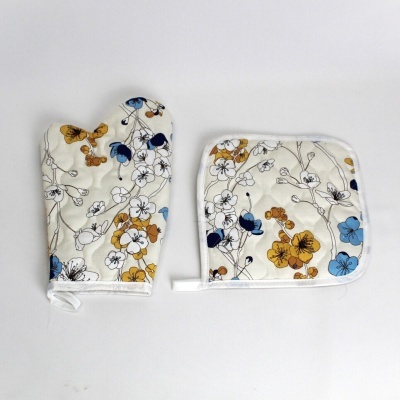 Luva e apoio de panela com padrão floral colorido sobre fundo branco