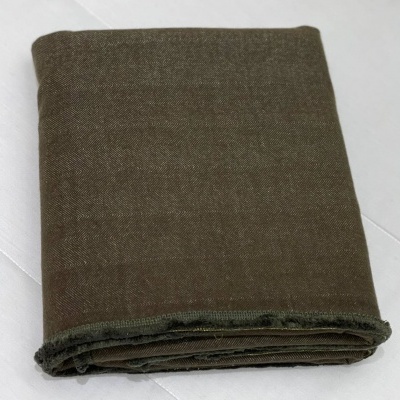 tecido castanho escuro dobrado sobre superfície branca