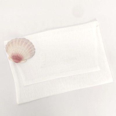 Toalha branca com concha natural no canto superior