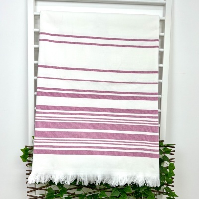 toalha branca com riscas rosa pendurada em suporte branco com folhas verdes