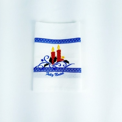 toalha branca com bordado de velas acesas e texto Feliz Natal