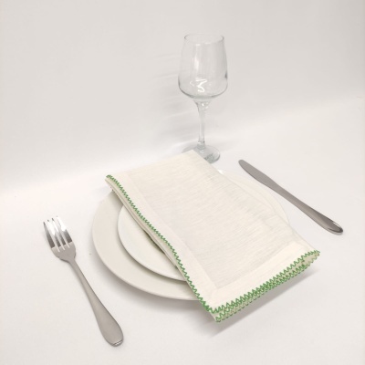 Conjunto de pratos, talheres, guardanapo e copo sobre mesa branca