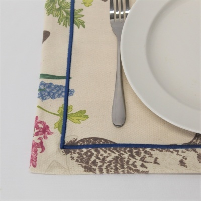 Toalha de mesa floral com prato branco e talheres