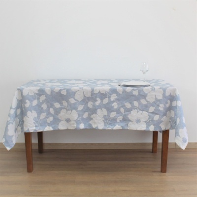 toalha de mesa azul com padrão floral branco sobre mesa de madeira