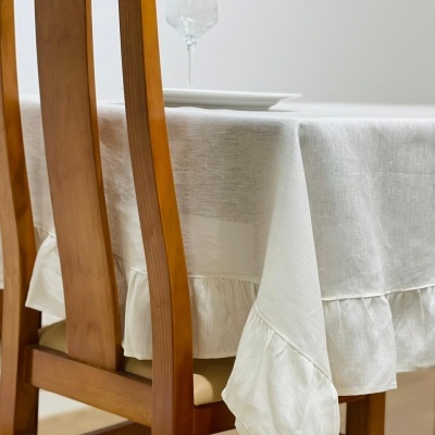 Mesa de madeira com toalha branca e cadeira de madeira