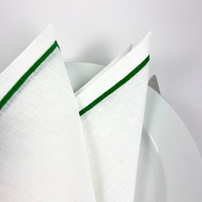 Guardanapo branco com risca verde dobrado num prato branco