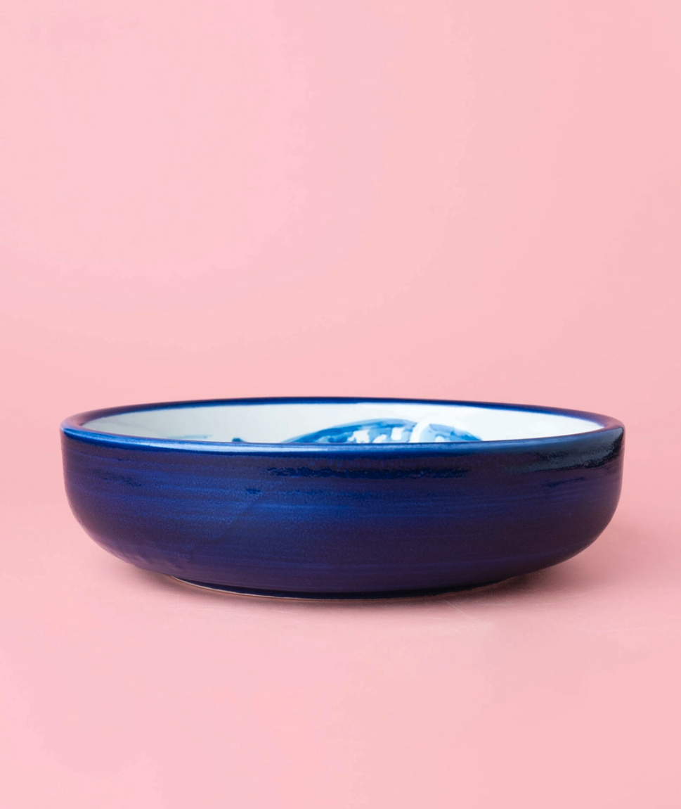 TAÇA RALADOR GRANDE "ATUM" ALFAR TIERRA COCIDA Tigela de cerâmica azul escura com interior branco e padrão azul sobre fundo rosa