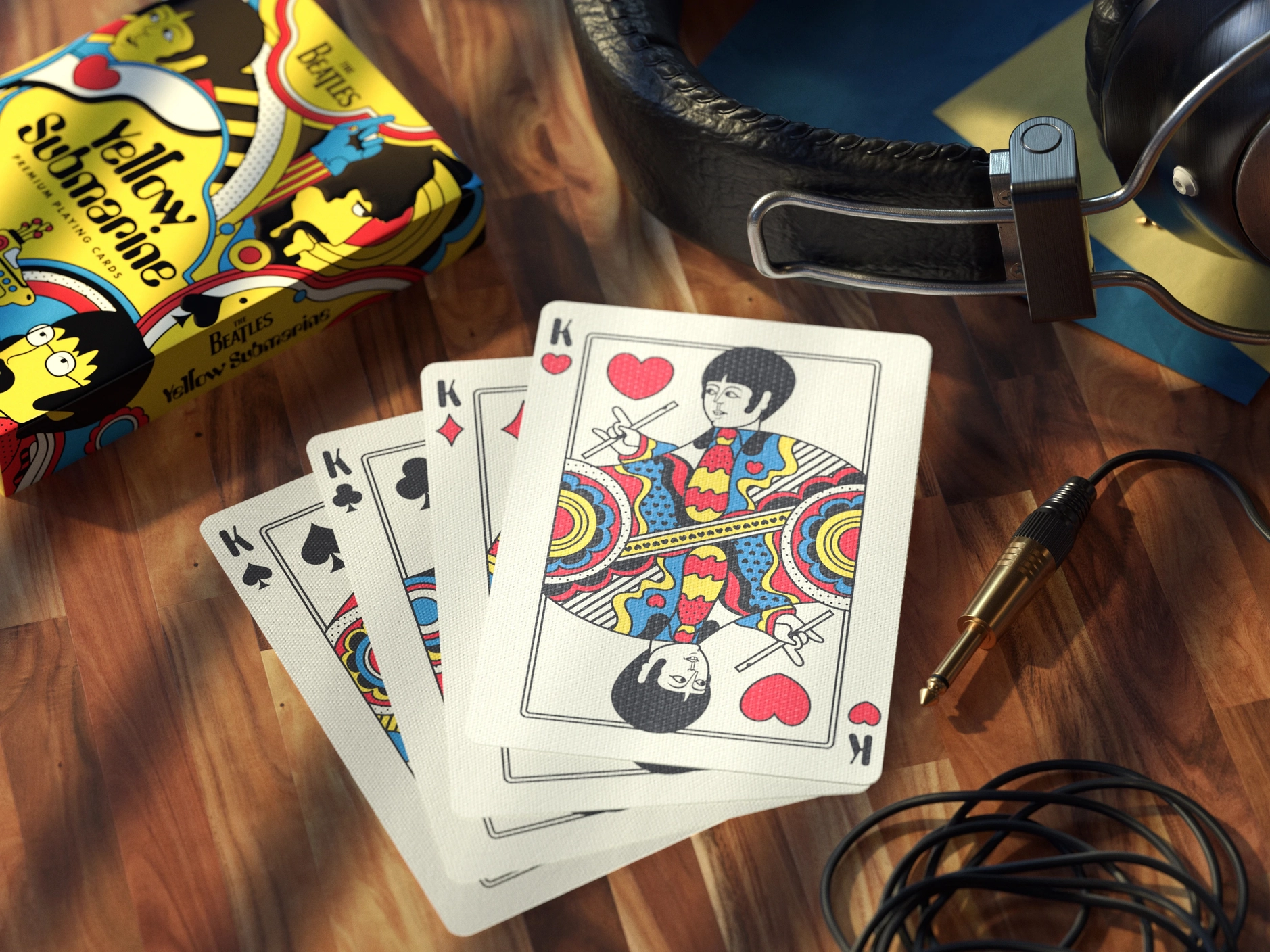 BARALHO DE CARTAS "YELLOW SUBMARINE, THE BEATLES " THEORY11 CARDSHOUSE Baralho de cartas The Beatles Yellow Submarine com caixa colorida sobre mesa de madeira e auscultadores ao lado
