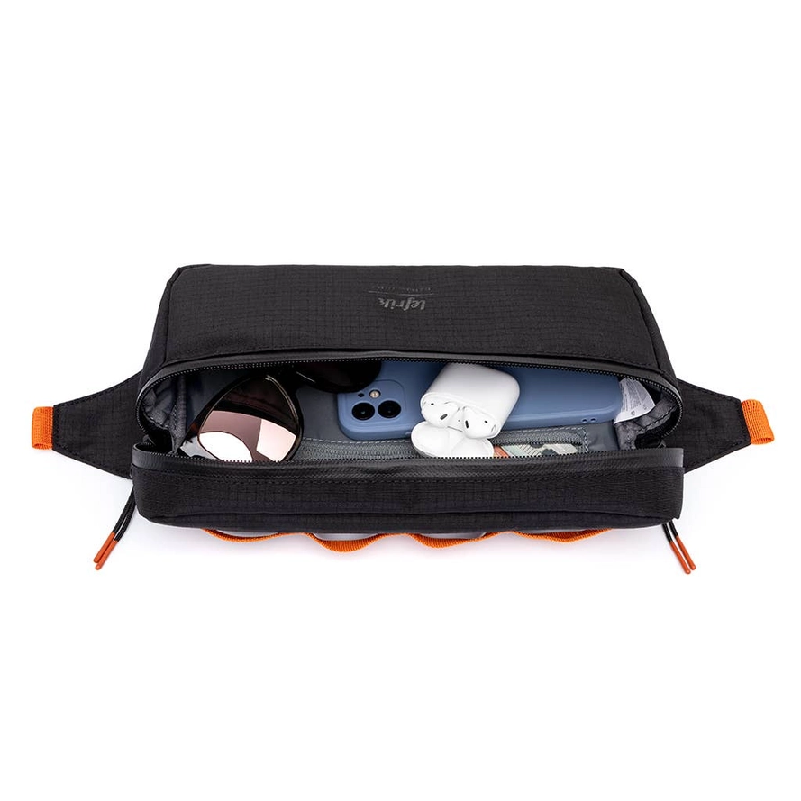 CORE BIKE BAG VANDRA RIPSTOP LEFRIK Mala preta aberta com telefone azul, auscultadores brancos e caixa redonda no interior