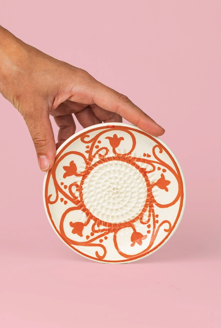 PRATO RALADOR PEQUENO "AZAHARA" ALFAR TIERRA COCIDA Prato cerâmico branco com flores laranja e textura circular no centro.