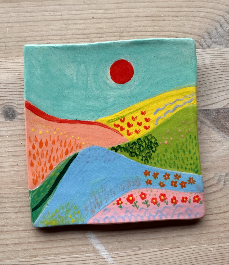 AZULEJOS PAISAGEM CERAMICA KIKA Azulejo cerâmico pintado à mão com paisagem abstrata colorida sobre superfície de madeira