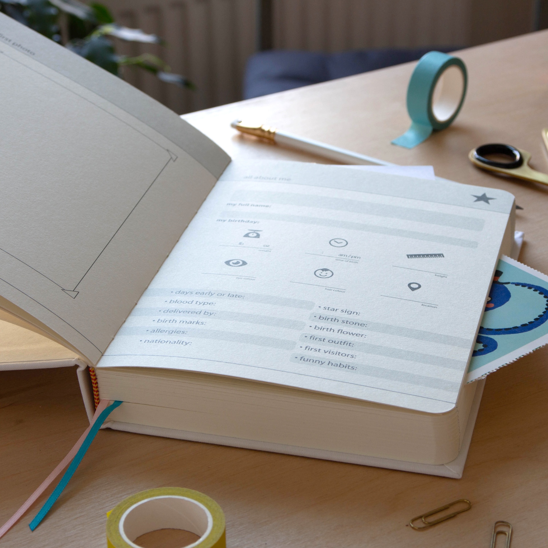 MY BABY JOURNAL SUCK.UK Caderno aberto grande com folhas impressas e itens de escritório numa mesa de madeira