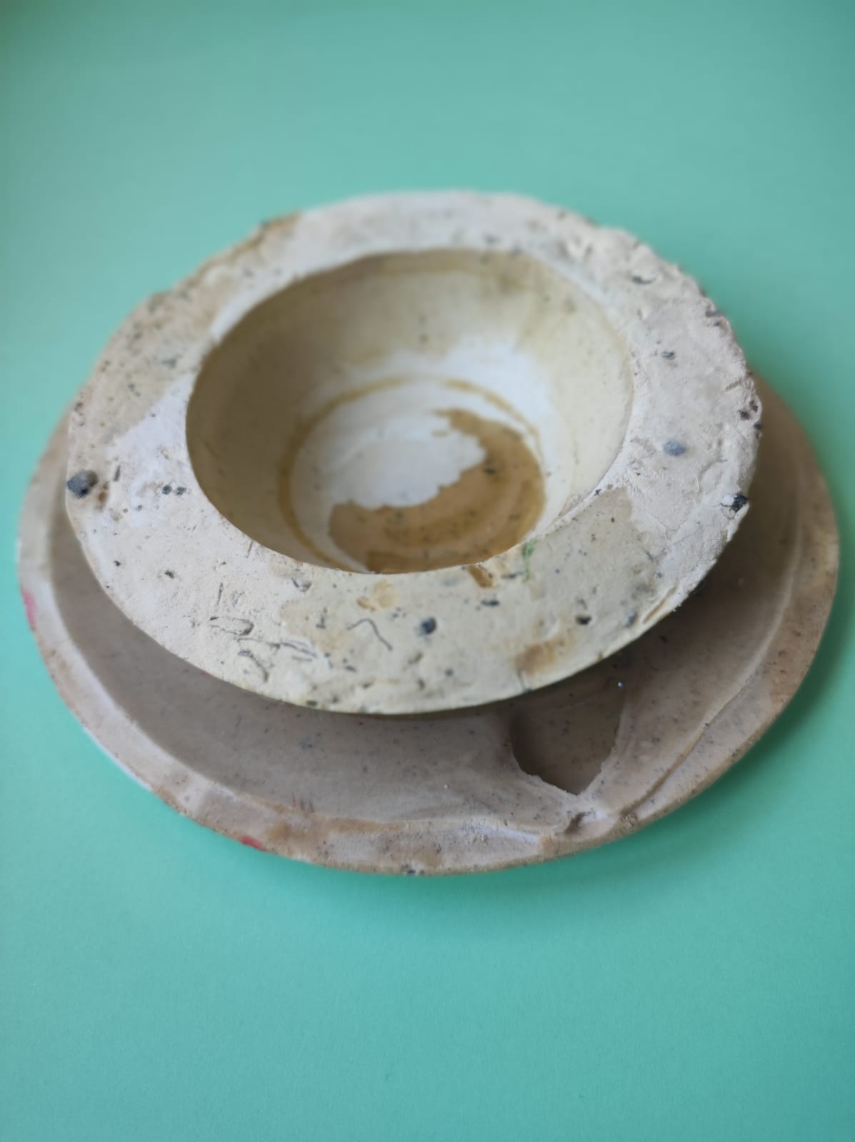 CONJUNTO VERDE DE CHÁ INGLÊS "TABLEWARE FOR ISOLATION" MARQUES MARQUES Dois pratos rústicos empilhados sobre fundo verde