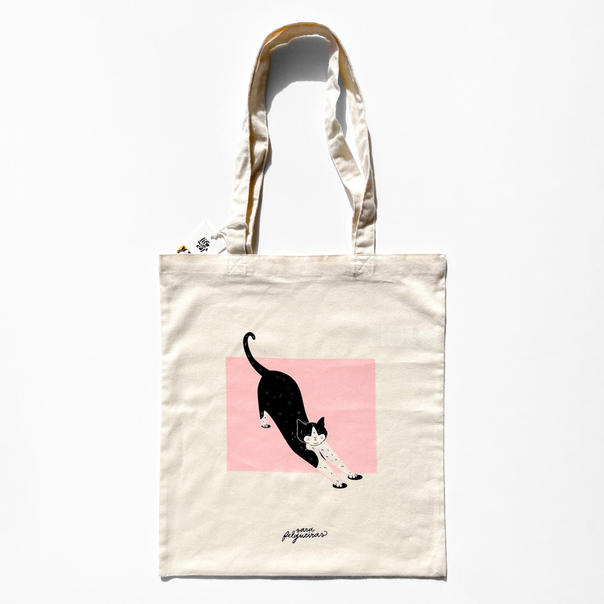 TOTE BAG "STRETCHING" SARA FELGUEIRAS Saco de tecido cru com desenho de gato preto e branco alongando-se e fundo rosa
