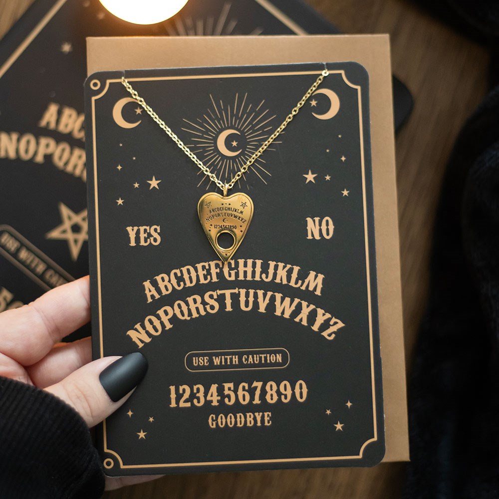 CARTÃO DE SAUDAÇÃO COM COLAR "OUIJA BOARD" SOMETHING DIFFERENT Colar dourado com pendente em forma de coração e cartão decorativo preto com letras e números em bege