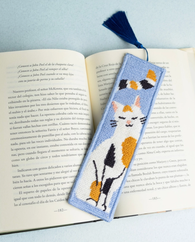 "THE GREAT CATSBY BOOKMARK NEEDLE STICH KIT " UNWIND STUDIO Marcador de livro bordado com desenho de gato colorido sobre livro aberto