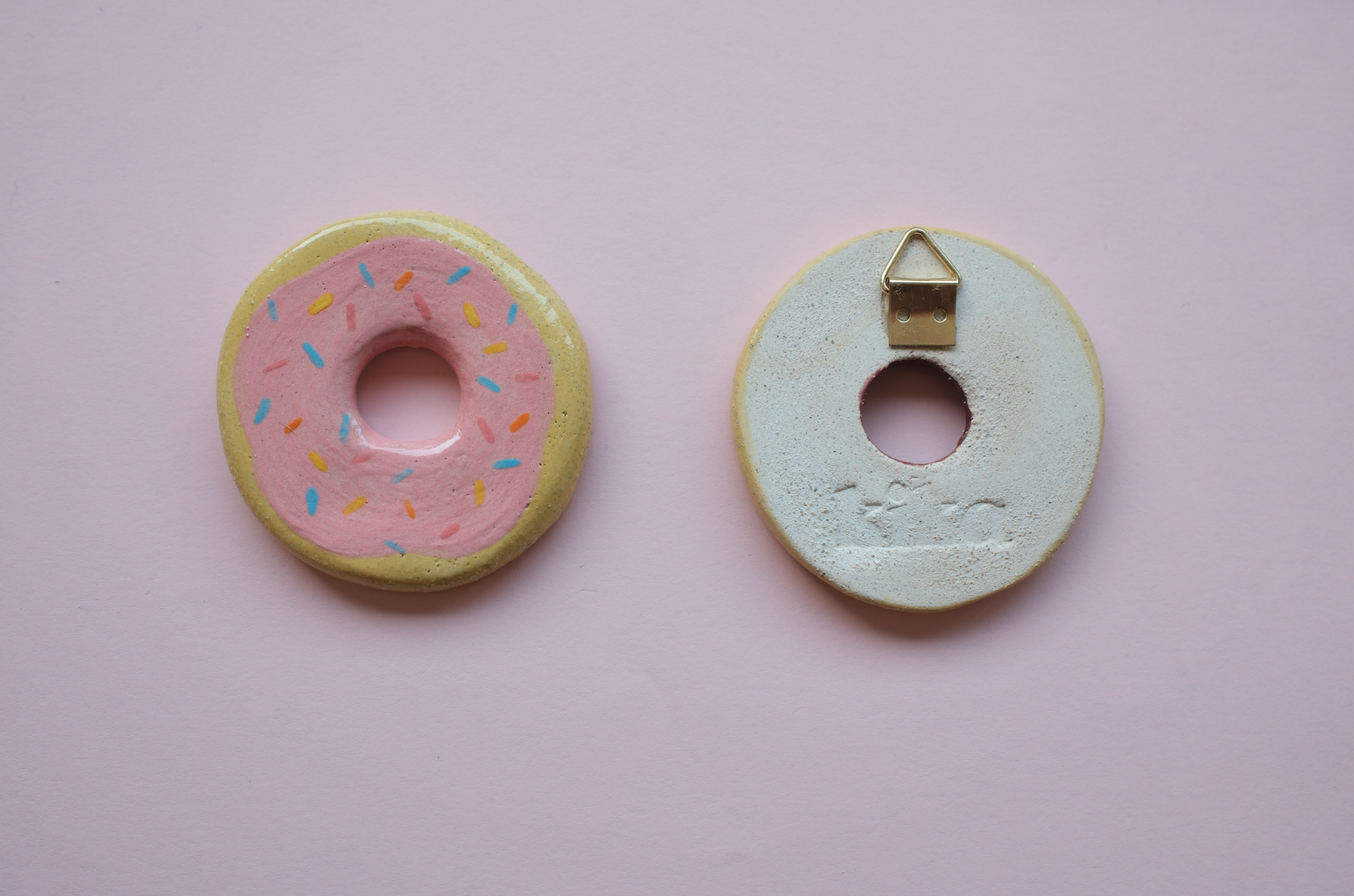 PEÇAS DE CERÂMICA "BREAKFAST FOR DINNER" KIKA Enfeites de donut rosa e branco sobre fundo rosa