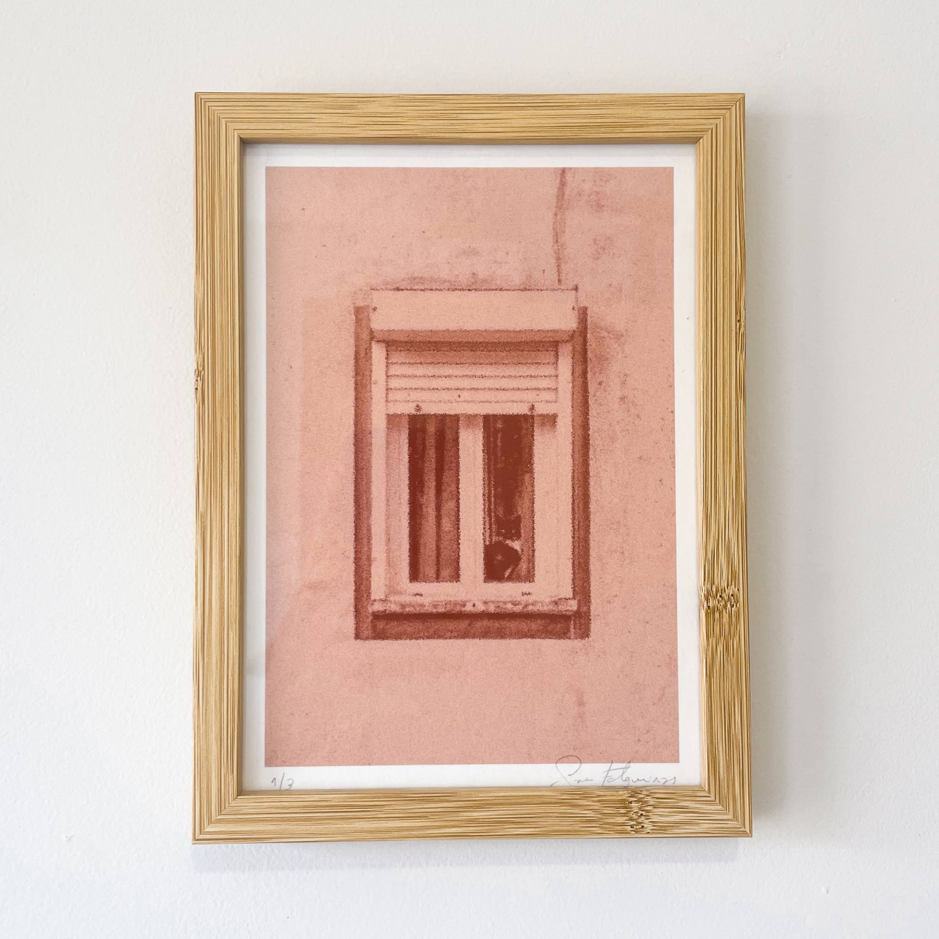 FOTOGRAFIA "RAMALDE II" SARA FELGUEIRAS Quadro artístico com moldura de madeira clara e impressão em tons de vermelho e rosa de uma janela