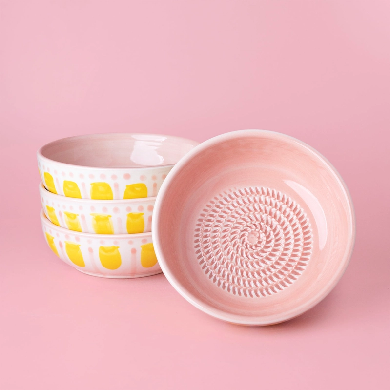 TAÇA RALADOR "VALENTINA - ROSA E AMARELO" ALFAR TIERRA COCIDA Conjunto de tigelas cerâmicas amarelas, brancas e rosa com textura em fundo rosa