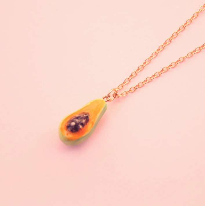 COLAR "PAPAYA" SIAMESE TWIN STUDIO Colar com pendente de fruta colorida sobre fundo rosa