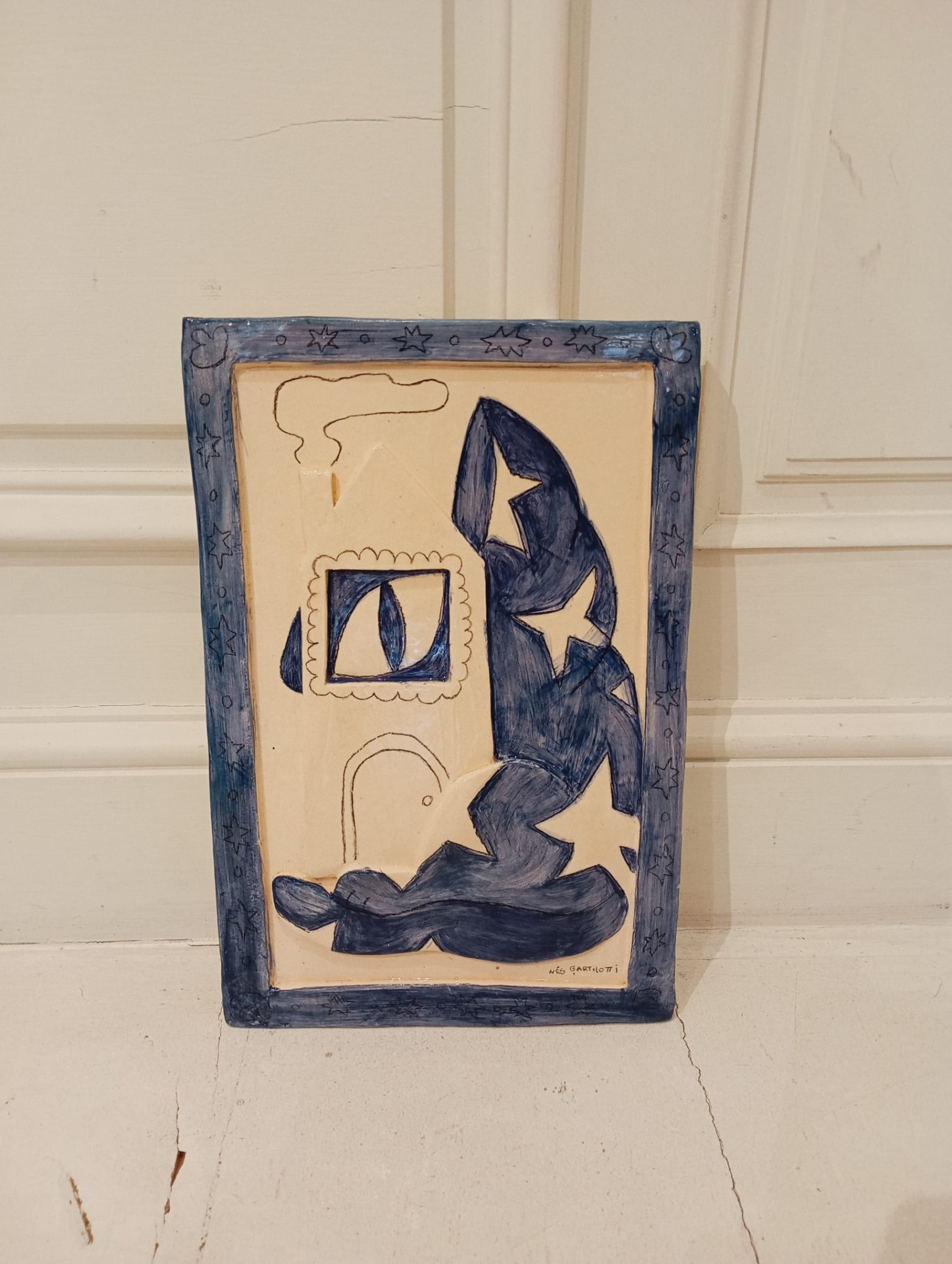PEÇA DE CERÂMICA "GATO À JANELA" INÊS BARTILOTTI Placa decorativa em cerâmica com padrão abstrato azul e bege com borda azul estrelada.