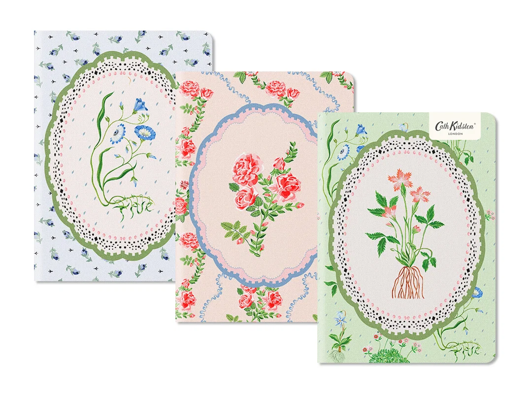 Cadernos com capas de tecido floral com bordados e texto Cath Kidston.