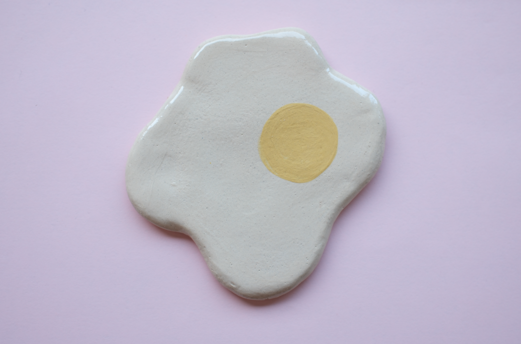 PEÇAS DE CERÂMICA "BREAKFAST FOR DINNER" KIKA Base em cerâmica branca com círculo amarelo, sobre fundo rosa claro