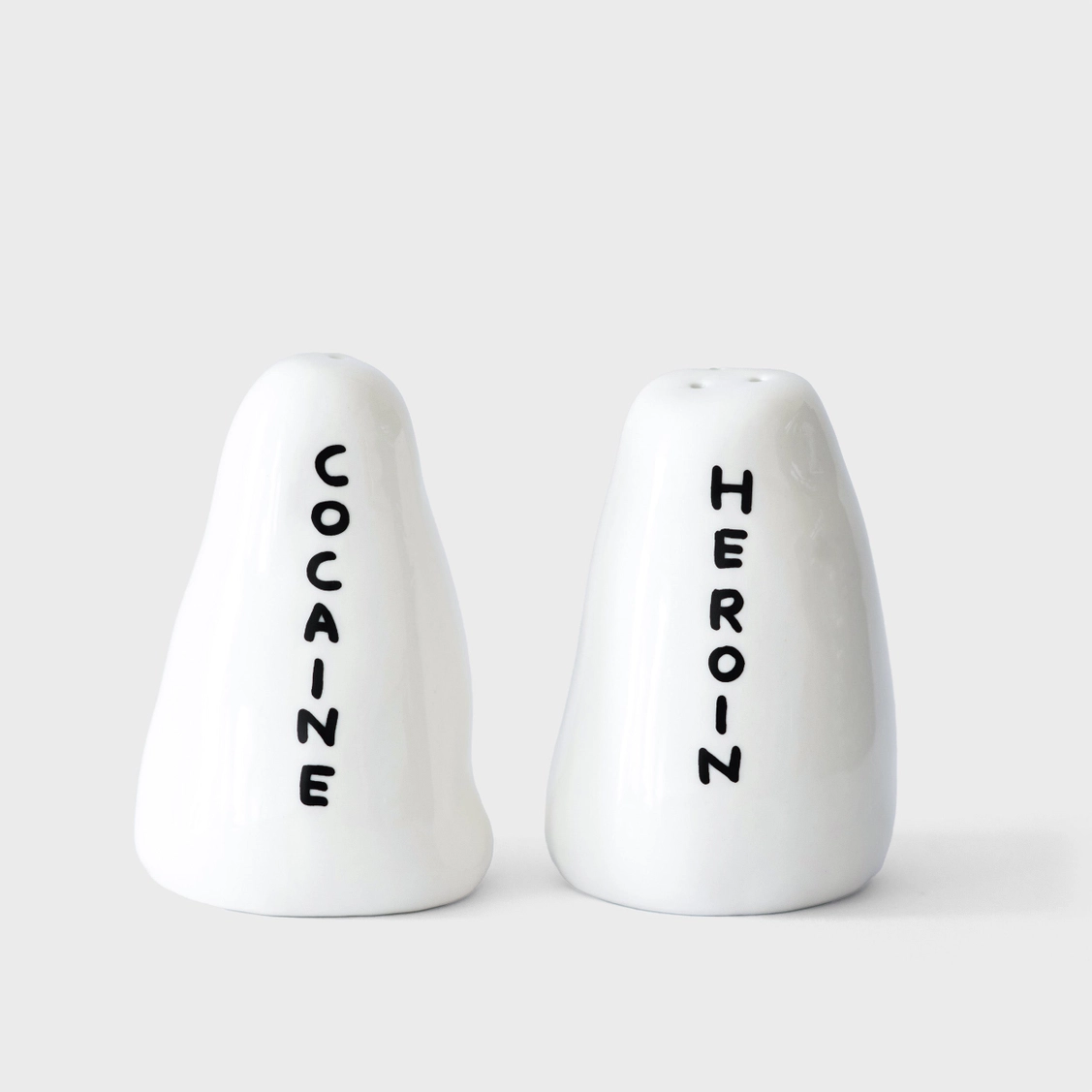 SALEIRO/PIMENTEIRO "COCAINE, HEROIN" - DAVID SHRIGLEY conjunto de saleiro e pimenteiro em cerâmica branca com texto COCAINE e HEROIN