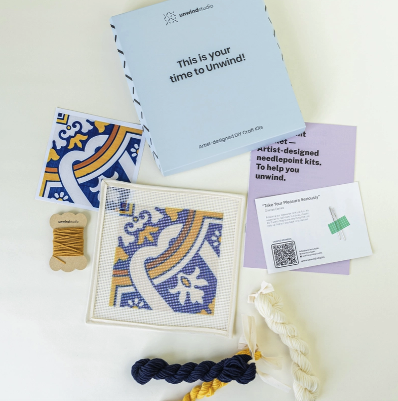 "AZULEJO PORTUGUÊS - CEDOFEITA" - UNWIND STUDIO Kit de ponto cruz com padrão colorido e linhas para bordar, embalagem azul da Unwind Studio.