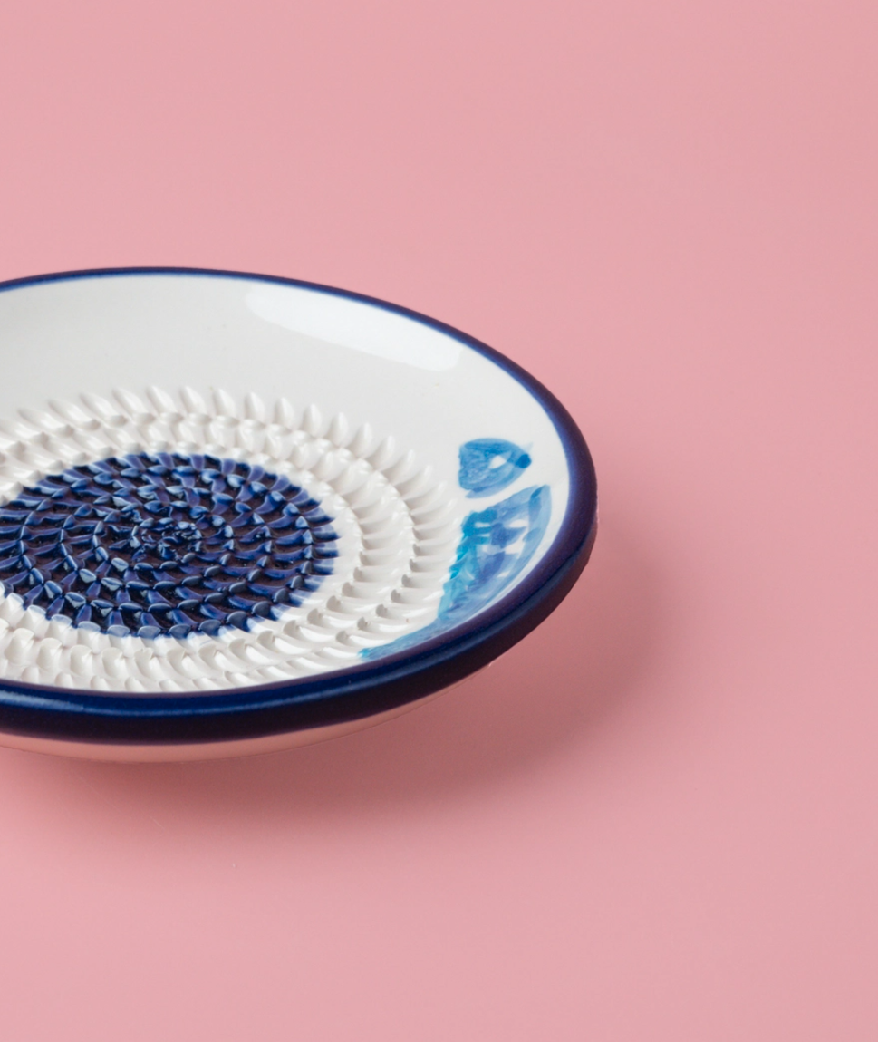 PRATO RALADOR PEQUENO "ATUM" ALFAR TIERRA COCIDA Prato cerâmico azul e branco com textura em relevo num fundo rosa
