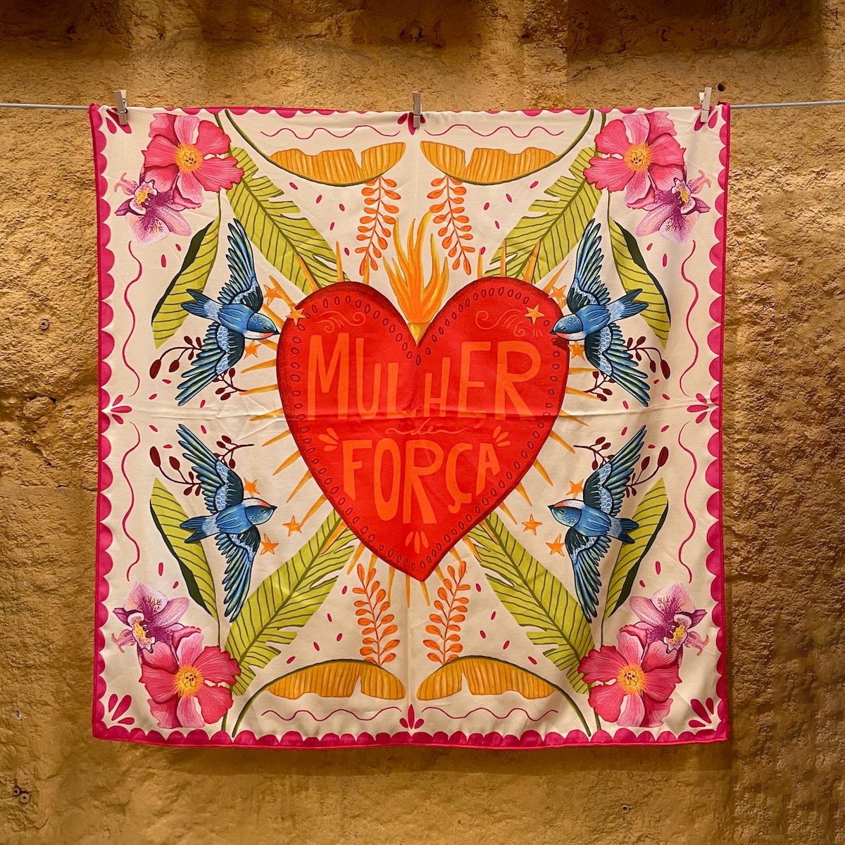 LENÇO "MULHER DE FORÇA" RITA ROBALINHO Lenço quadrado com padrão colorido e frase 'MULHER FORÇA' no coração vermelho central