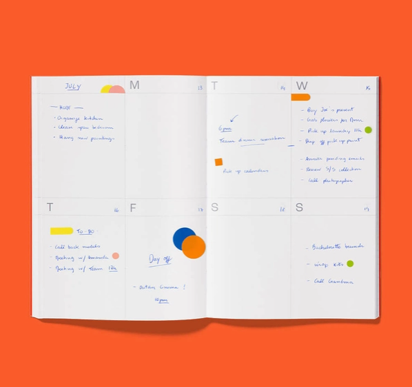 PLANNER A5 "UNDATED" VERMELHO MISHMASH Agenda aberta com anotações manuscritas e marcações coloridas num fundo laranja