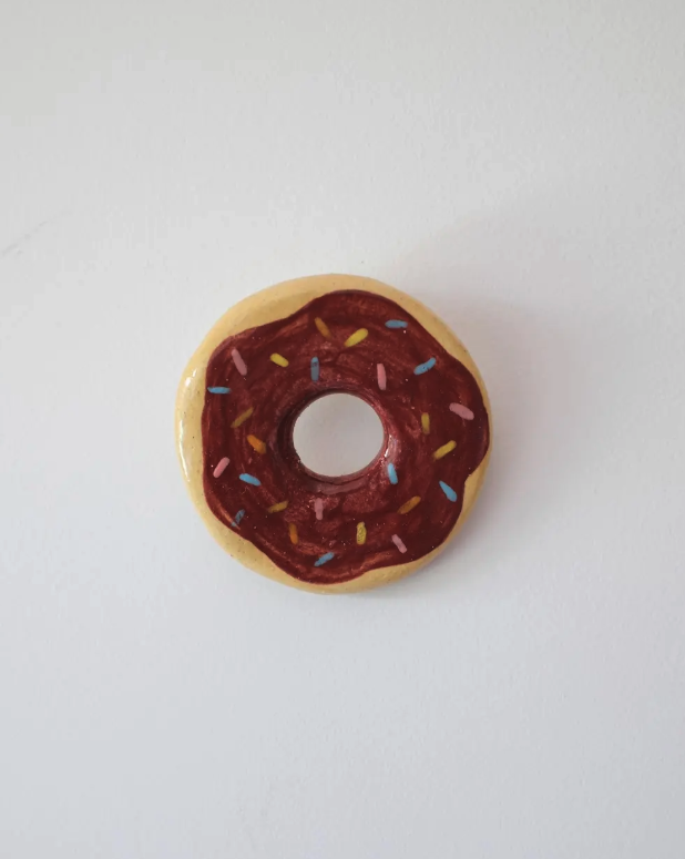 PEÇAS DE CERÂMICA "BREAKFAST FOR DINNER" KIKA Íman de geladeira em forma de donut com cobertura castanha e confeitos coloridos