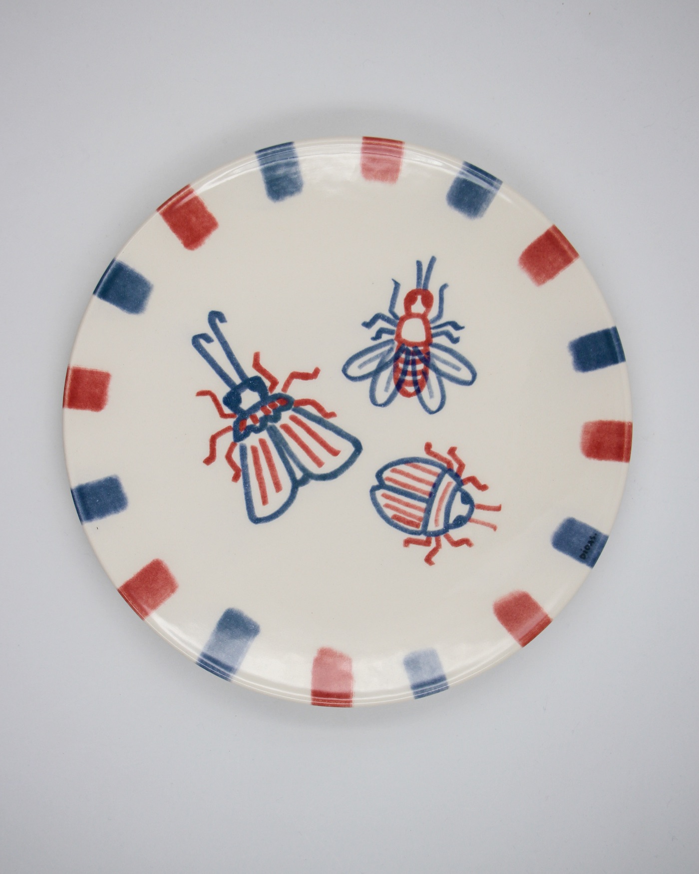 PRATO ILUSTRADO "BICHOS" DIOGO PAIXÃO E PÓ DE BARRO Prato de cerâmica decorado com insetos e borda a quadros vermelhos e azuis
