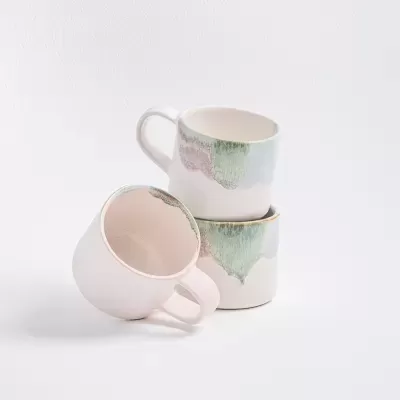 Três chávenas de cerâmica decoradas com padrão pastel em fundo branco