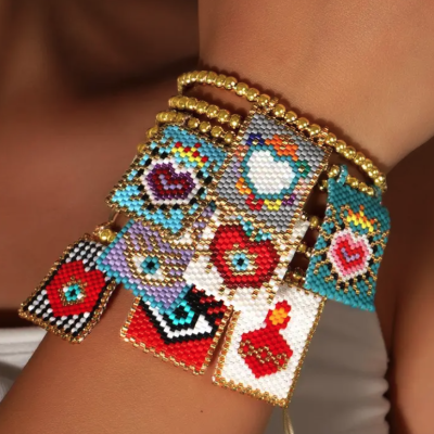 Pulseiras com pendentes de miçangas coloridas e douradas no pulso