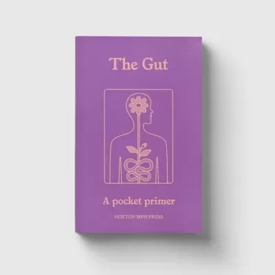 Livro roxo The Gut com ilustração de silhueta humana e flor